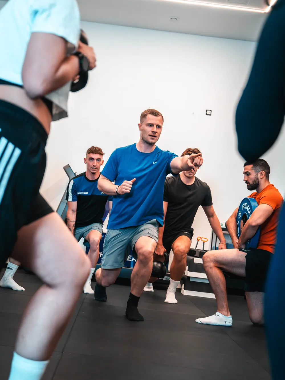 Maxence Ponthus montre une fente chargée au kettlebell devant les participants